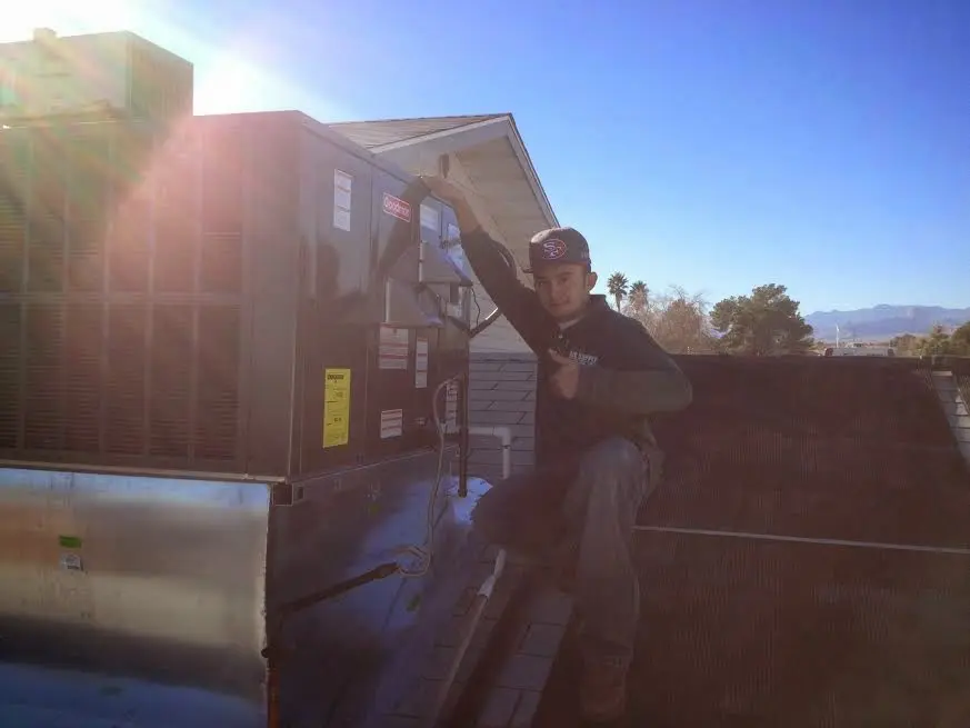 HVAC technician performing AC Tune-Up on a rooftop unit in Midland